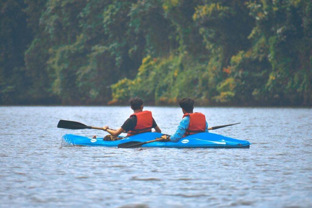 pexels-photo-1682744-1682744 Two men enjoying a kayaking adventure on a tranquil river surrounded by lush greenery.